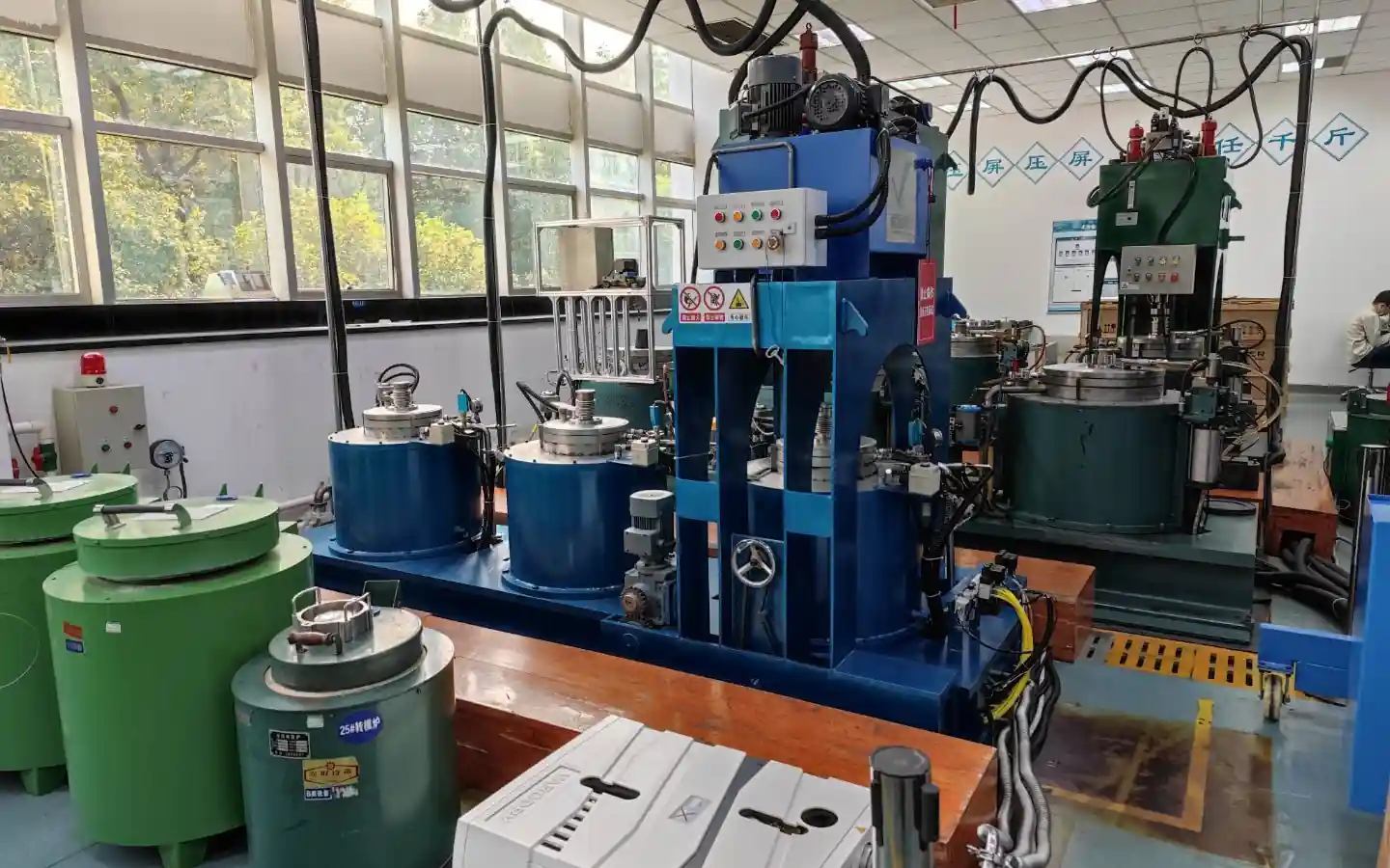 VMPE vacuum hot press furnaces with vertical press frames and vacuum chambers in a production workshop