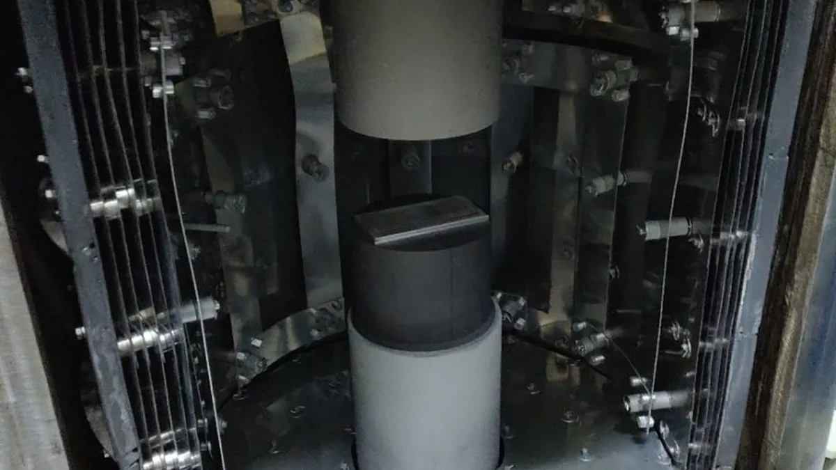 Open vacuum hot press chamber showing press tooling and the heated process zone
